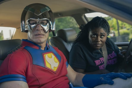 A man and a woman in a car, the man with a metallic mask over his face
