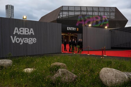 A red carpet in front of the Abba arena on the show's opening night. The Abba logo is seen at the gates and on the side of the arena.