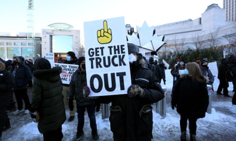 A counter-protester holds a sign as truckers and supporters protest against mandates and restrictions related to Covid-19 vaccines in Ottawa, Canada.