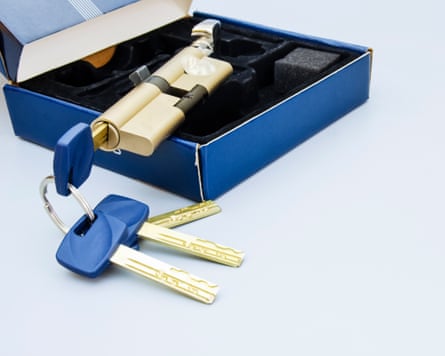 Keys and lock cylinder on a grey table.