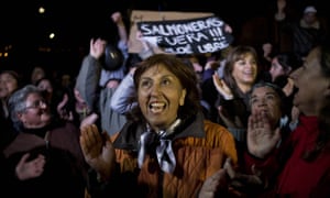 People shout slogans as they listen to a speech during a protest on Chiloe Island, Chile. The sign in the background reads in Spanish: “Salmon farms out! Free Chiloe.” Local residents blame large-scale salmon farms for the algae bloom.