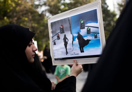 An Iranian woman holds a placard during a protest to ask for the revival of the hijab and chastity on Iranian state TV as part of a campaign against the threats against Islamic values.