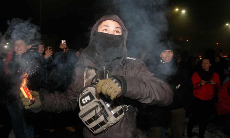 A protester with a smoke grenade at the Russian embassy in Kiev on Sunday. 