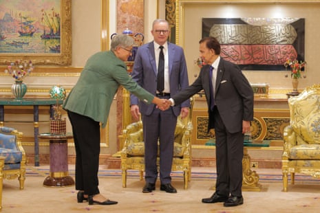 Brunei's Sultan Hassanal Bolkiah (R) shakes hands with Penny Wong (L) as Anthony Albanese (C) looks.