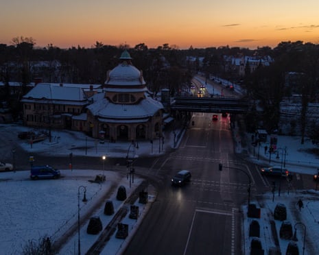 An aerial view of a snow-covered Berlin roundabout and train station with wet roads and vehicle lights during the blackout