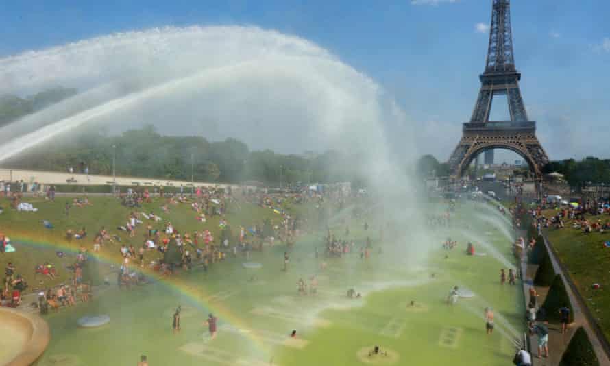 People cool off in and around a large water pool at Trocadero, across the Seine from the Eiffel Tower.