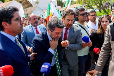 Chega party leader André Ventura receives help as he departs a campaign rally after falling ill ahead of the legislative elections, in Odemira, Portugal.