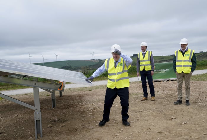 Boris Johnson standing next to a solar panel on a visit to the the Scottish Power Carland Cross Windfarm in Newquay, Cornwall, this afternoon.