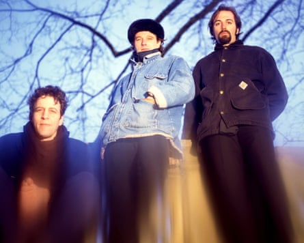 One man crouching and two men standing all look at the camera.