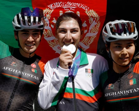 Afghanistan’s Fariba Hashimi celebrates with her medal alongside her sister Yuldoz Hashimi and teammate Zahra Rezayee.