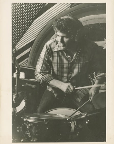 black and white picture of a man in a flannel shirt drumming