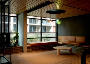 A residential lounge with leather bench seating, round coffee table, and floor-to-ceiling windows