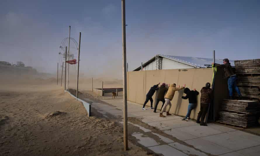 People secure a building against a strong wind on the beach of Scheveningen, the Netherlands. Storm Eunice, the fourth storm of this year, is crossing the Netherlands with very strong wind gusts of 100 to 120 kilometers per hour.