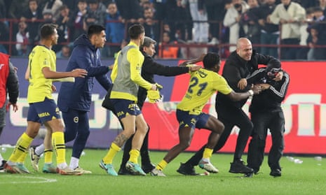 A fan (right) attacks Fenerbahce players after Trabzonspor’s 3-2 defeat