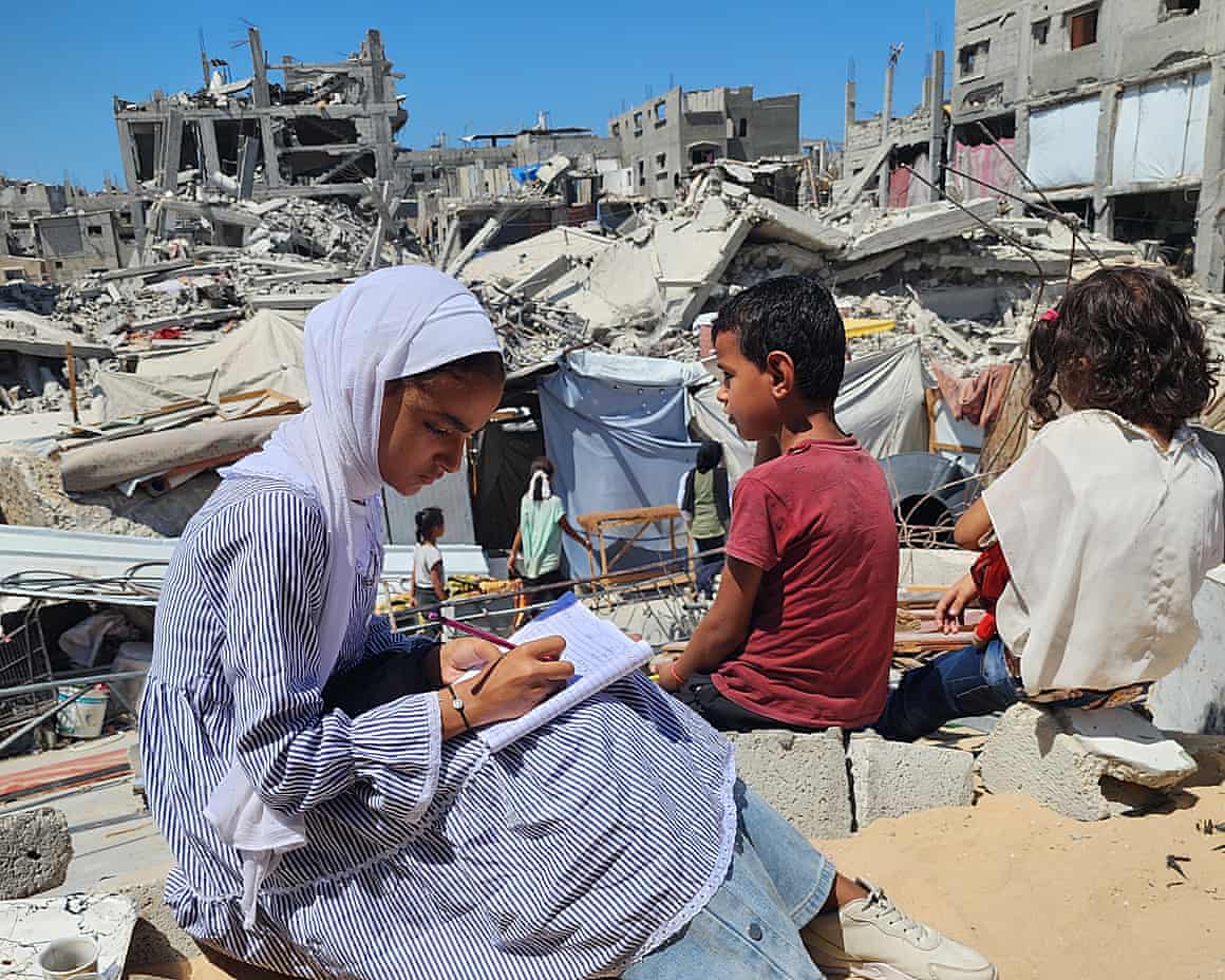 Children do homework amid the rubble of bombed-out buildings
