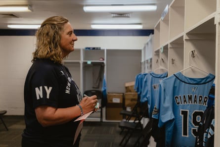 A coach looks at locker while writing a message