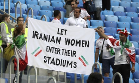 People supporting Iranian women holding a banner in the stands during the match between Morocco and Iran.