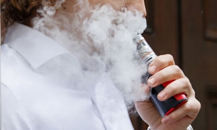 A smoker engulfed by vapours as he smokes a vaping device