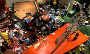 Environmental activists spent 15 minutes lying in silence on the floor of the Queensland Museum’s dinosaur exhibit