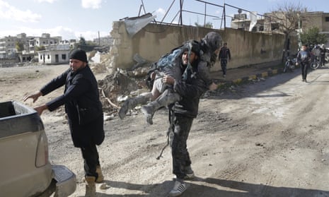 A man carries an injured woman in a site hit by what activists said were airstrikes carried out by the Russian air force in the rebel-controlled area of Maaret al-Numan town in Idlib province, Syria, on Saturday.