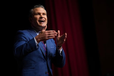 a man in a suit speaks and gesticulates