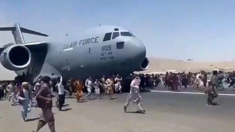 Afghans climb on to plane during takeoff in attempt to flee Taliban – video