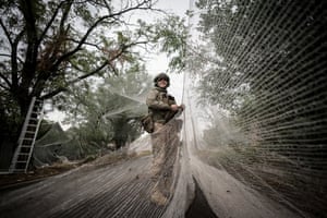 A person in military clothing handles netting