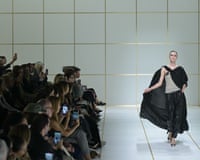 A model walks the Giorgio Armani runway in a flowing black cape.
