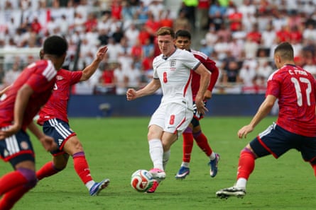 Elliot Anderson of England passes the ball out of a crowd of Costa Rica players.