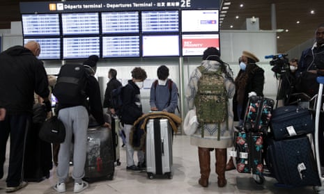 Travellers at Paris Charles de Gaulle airport after the US banned travel from 26 EU countries