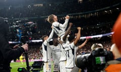 Real Madrid's Luka Modric is held aloft by his teammates after scoring the late winner against Sevilla.