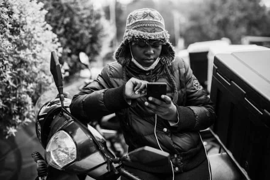 Ghost riders: the invisible lives of Johannesburg food couriers – photo essay | South Africa 21 Rebecca waits for orders outside a restaurant