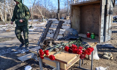 A man in military uniform walks past a makeshift memorial at the rubble of a vocational school that Russian servicemen used as barracks, in Makiivka, Donetsk region, Ukraine.