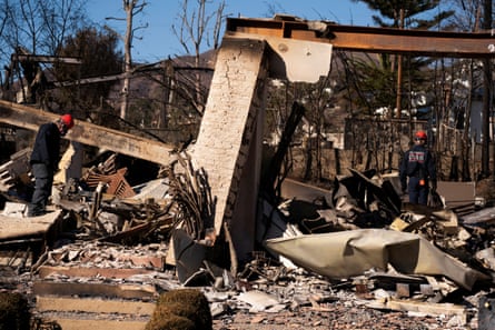 Officials search through the rubble of a house.