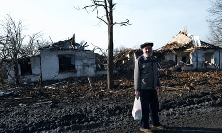 A local resident near destroyed buildings along the road to Avdiivka
