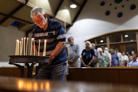 People lining up to approach candles at vigil
