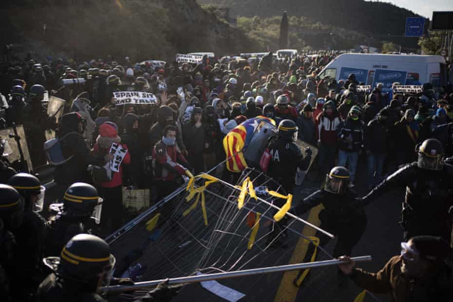 French police officers remove pro-Catalan independence demonstrators blocking a major highway border pass near La Jonquera between Spain and France, 12 November.