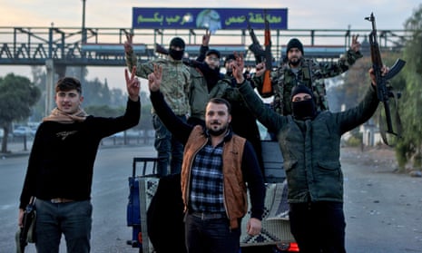 Suriyeli muhalif savaşçılar, 8 Aralık 2024 sabahı muhalif güçlerin Suriye'nin üçüncü büyük kenti Humus'a girmesinin ardından kentin girişinde kutlama yapıyor.