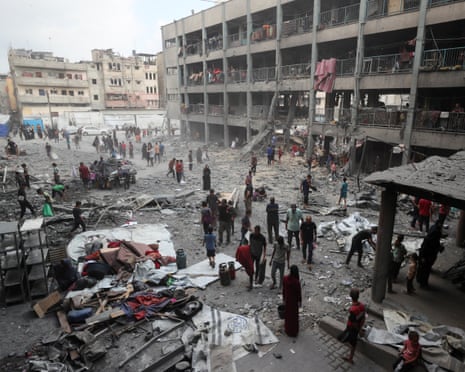 Palestinians inspect the damage at an Unrwa school sheltering displaced people that was hit in an Israeli air strike on Sunday in Gaza City.