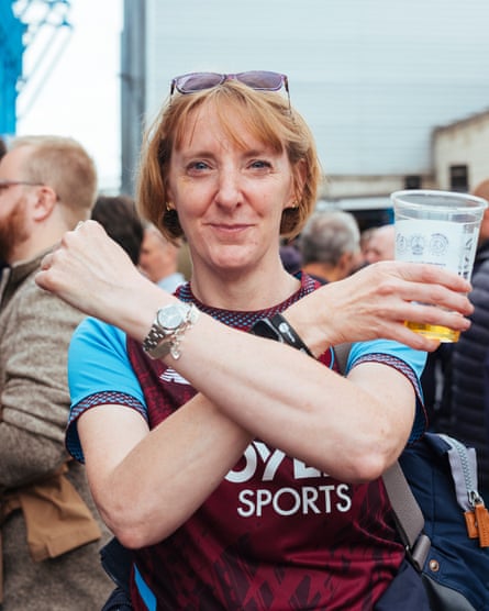A West Ham supporter makes Hammers sign to camera