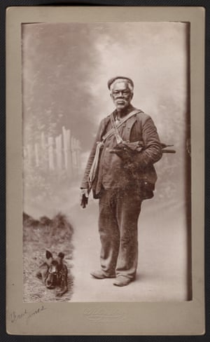 African American man standing with two bags on his shoulders and a small dog laying on the ground. Handwriting on corner reads Fred Jones