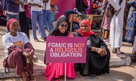 Women hold a sign saying: 'FGM/C is not a religious obligation.'