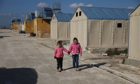 Two girls in front of flat-pack shelters sent by Ikea to earthquake-hit areas.