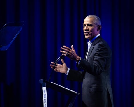a man in a suit speaks into a microphone
