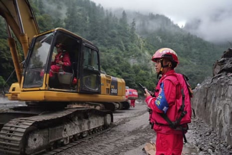 Machines clear a road at a mudslide-hit area