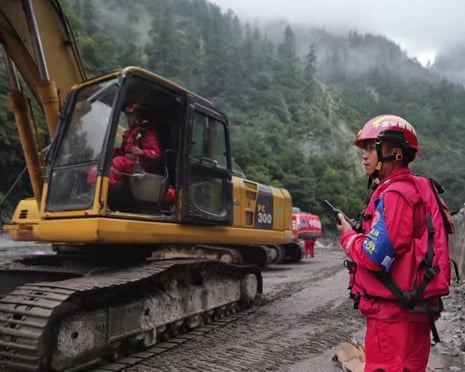 Machines clear a road at the mudslide-hit area in Gyirong County, in Tibet