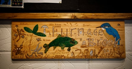 Wooden plaque with kids' names carved into it and pictures of a kingfisher and fish