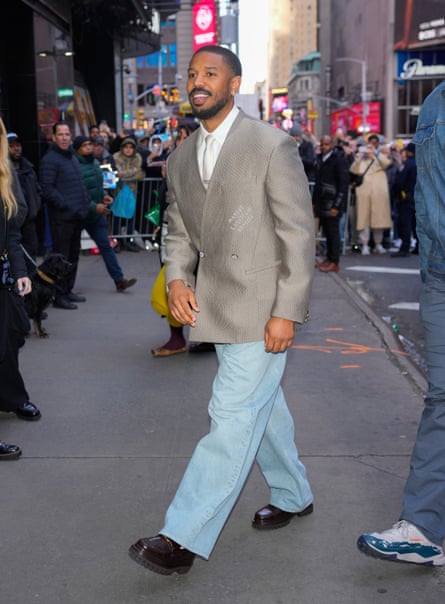 a man in a blazer and jeans