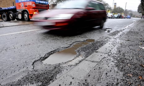 a car passes a water-filled kerbside pothole