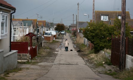 A person walking down a street of houses.